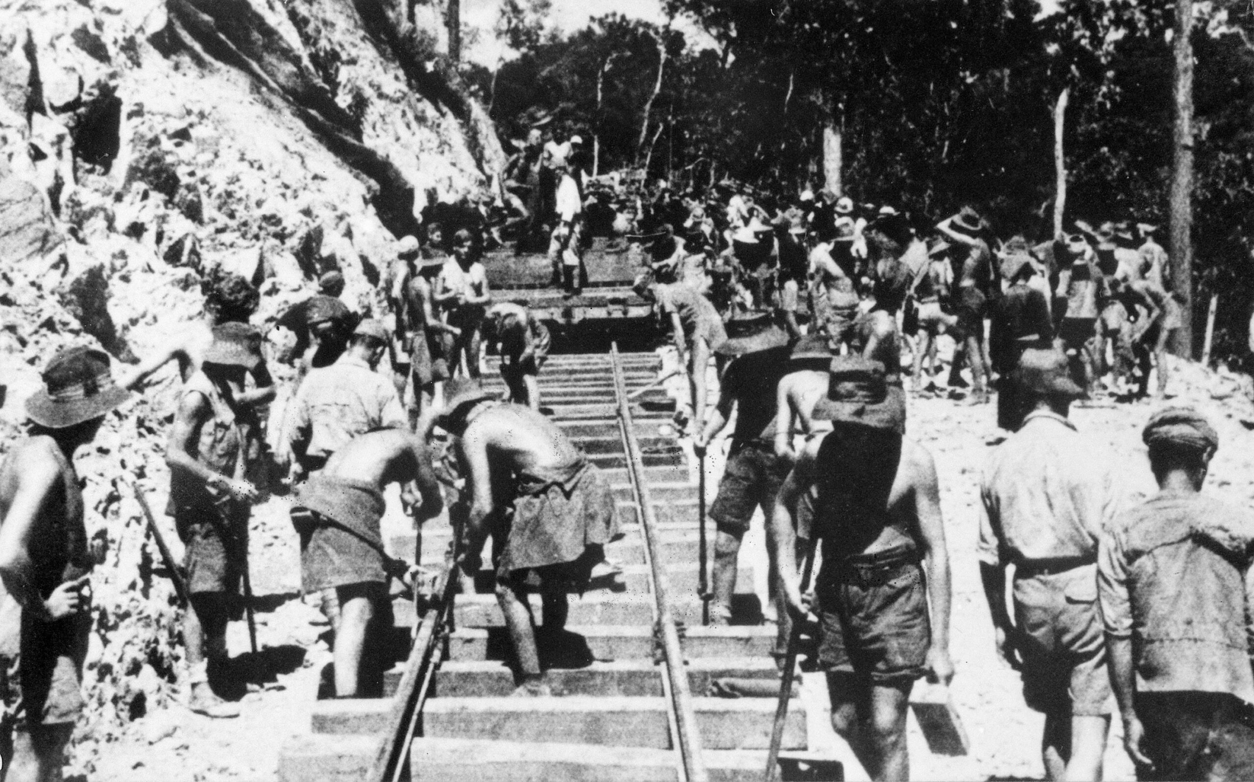 Australian and British prisoners lay track on the Burma-Thailand Railway in sweltering jungle heat. Another group of prisoners, mostly Americans, also labored on the rail line.