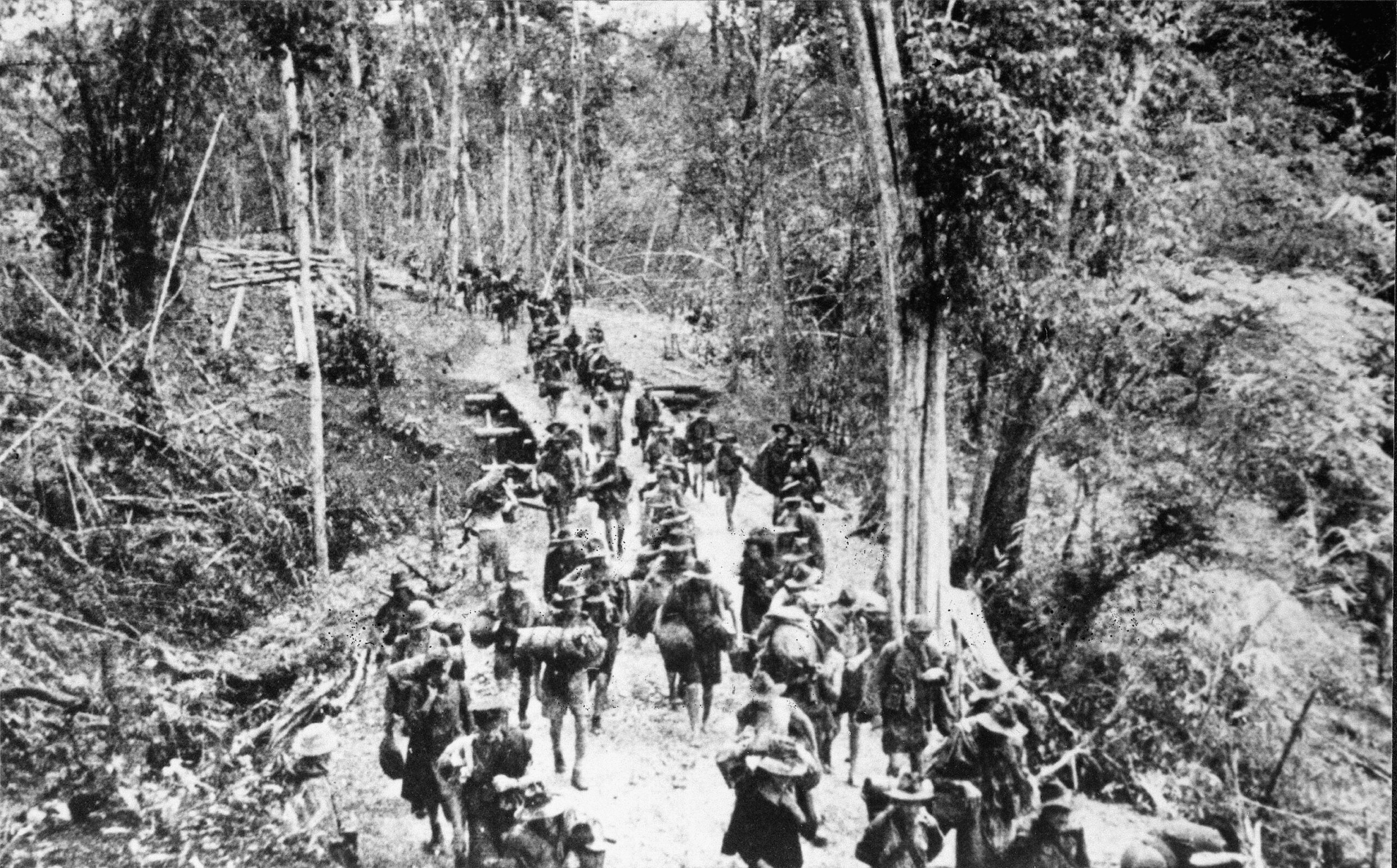 Marching to a new campsite, Allied prisoners of war are relocated to a new area to continue working on the Burma-Thailand Railway. Thousands of prisoners lost their lives working in harsh jungle conditions.