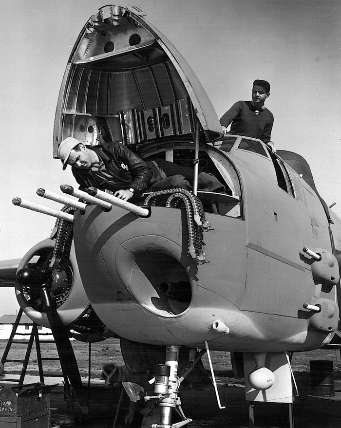  An airman inspects his B-25’s four nose mounted .50 caliber machine guns. The .75mm cannon can be seen on the lower right portion of the nose.