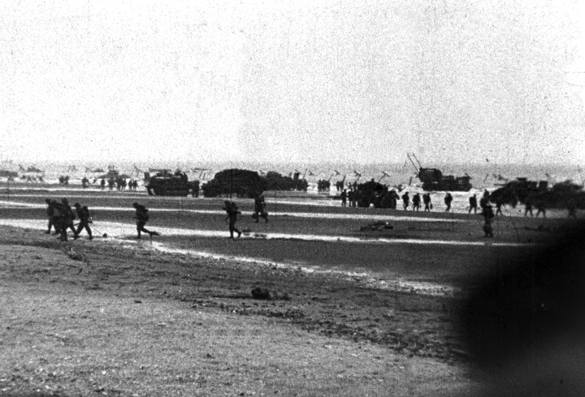 Tanks and other vehicles following, soldiers of the British 2nd Army move against German positions on Sword Beach during the morning of June 6. The British troops were able to push inland and establish a secure beachhead after overcoming stiff resistance.