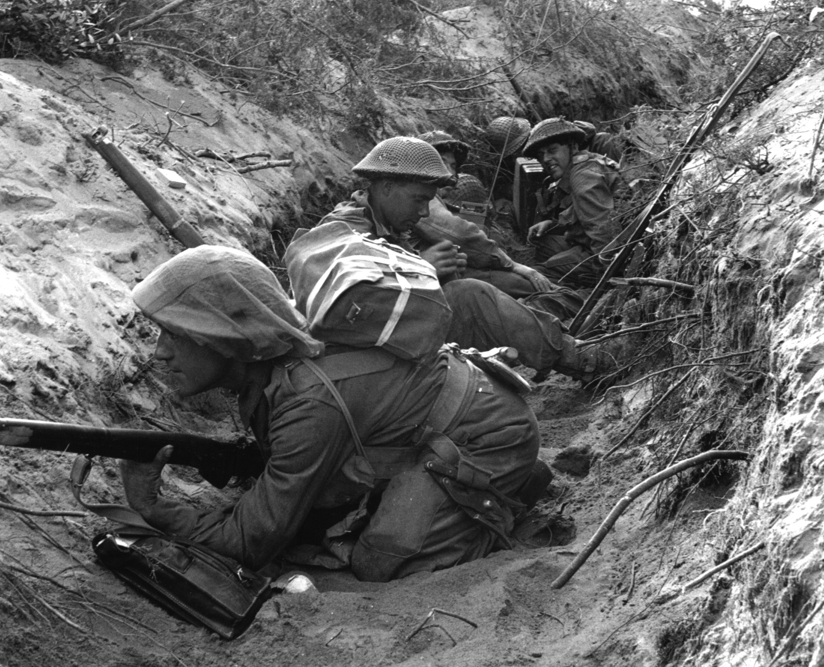 Occupying a captured German communications trench, soldiers of D Company, 1st Battalion, Green Howards prepare to move out during offensive operations at Anzio, Italy, on May 22, 1944.