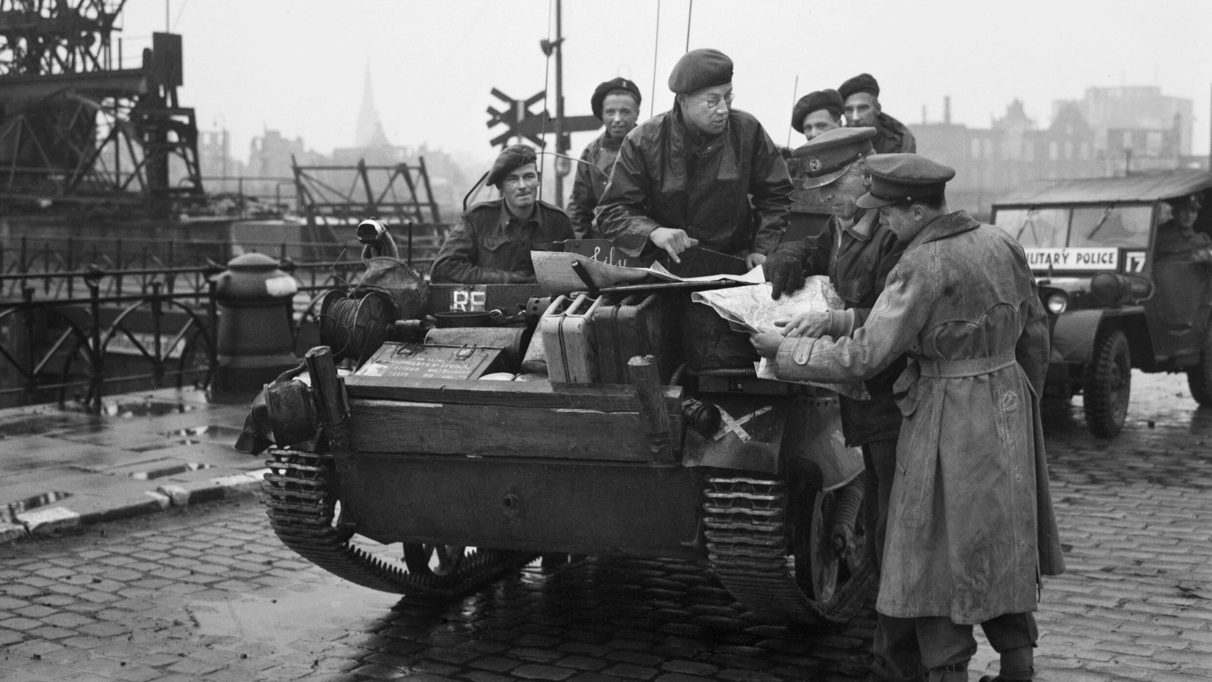 Lieutenant General Brian Horrocks, standing second from right, studies a map while conferring with officers aboard a universal carrier at the Europa Docks in Bremen, Germany, on April 27, 1945.