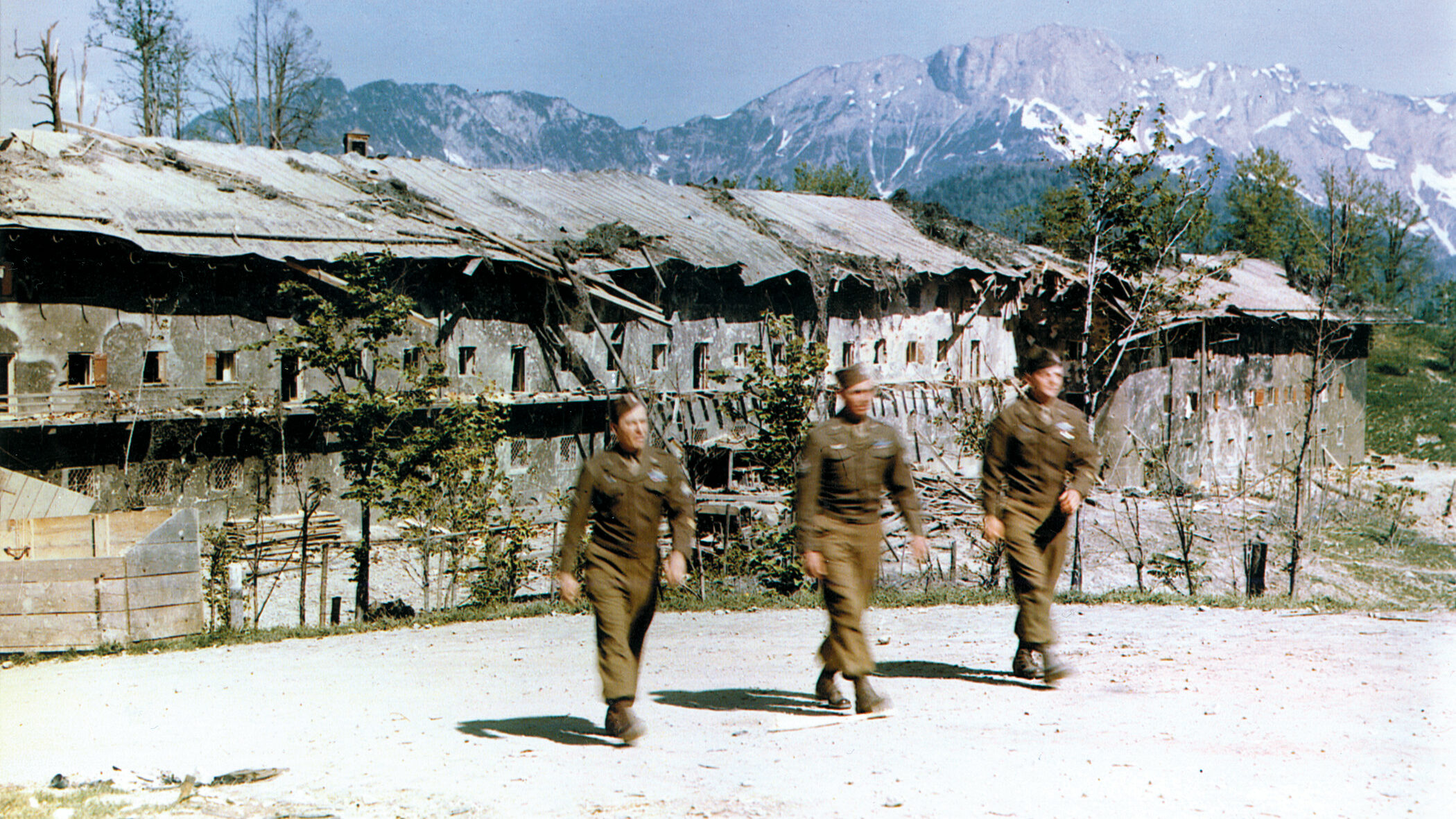 U.S. soldiers walk past the bombed-out barracks that once housed members of Adolf Hitler’s SS guard. The building was hit during an Allied bombing raid.