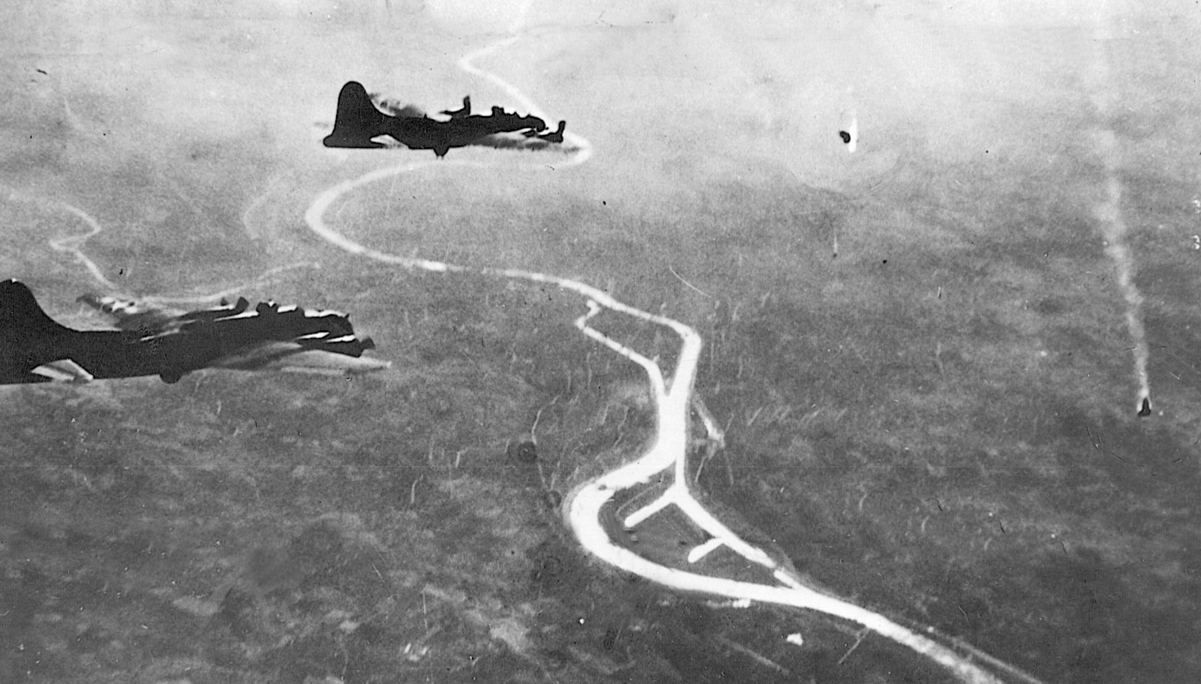 Pieces of a German Messerschmitt Me-110 twin-engined fighter spiral toward the ground as Eighth Air Force B-17s press on during a difficult raid against the manufacturing center of Schweinfurt, Germany.