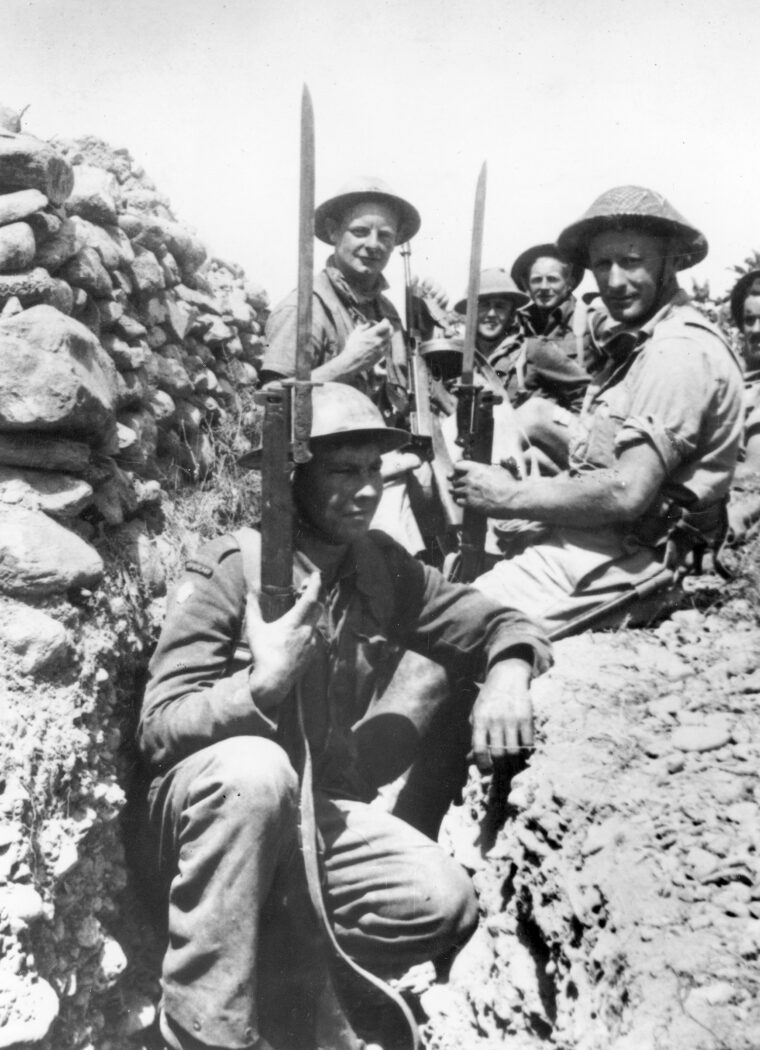 Congregating in a defensive position, British soldiers brandish their rifles equipped with sword bayonets fashioned in a pre-World War I pattern. These formidable weapons were valuable assets during the hand-to-hand fighting on Crete.