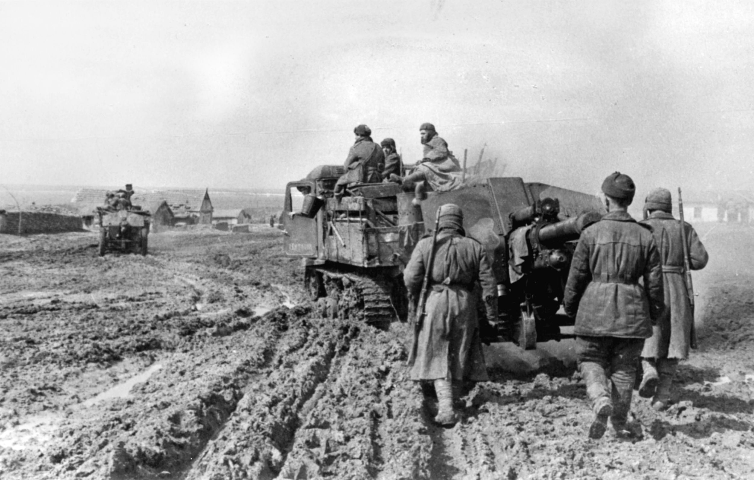 Soviet artillerymen follow the deployment of their weapon as it is towed along a muddy road by a prime mover. Massed Red Army artillery played a key role in numerous victories on the Eastern Front. This photo was taken in April 1944, as spring rains soaked the ground and made the movement of men and machines difficult.