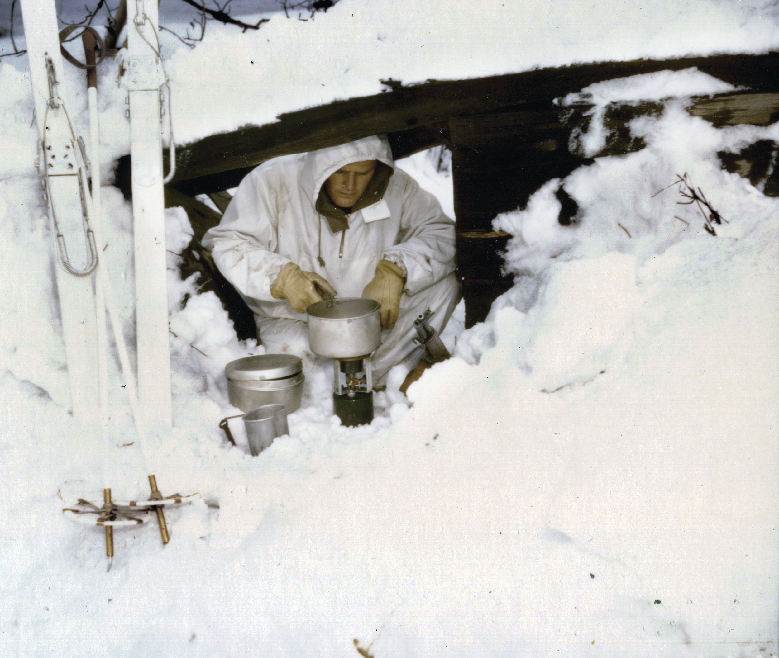 A soldier with the 1st Special Service Force cooks his lunch in an improvised dugout at Fort William Henry Harrison in Montana. 