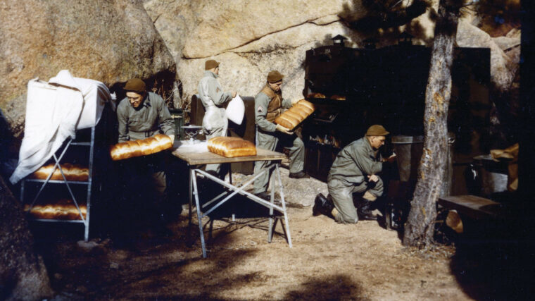 Soldiers make bread at an outdoor mobile bakery.