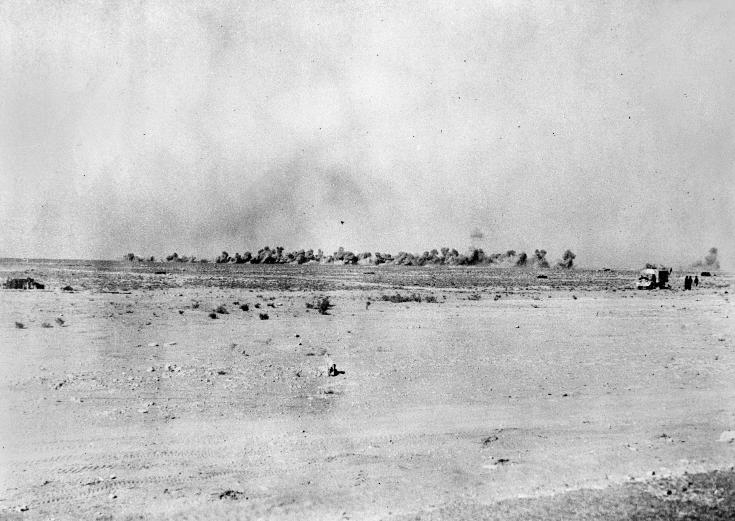 During the siege of the Italian defensive positions at Bardia on December 31, 1940, British artillery steadily bombards the Italians. Artillery fire played a key role in supporting infantry operations during Operation Compass.