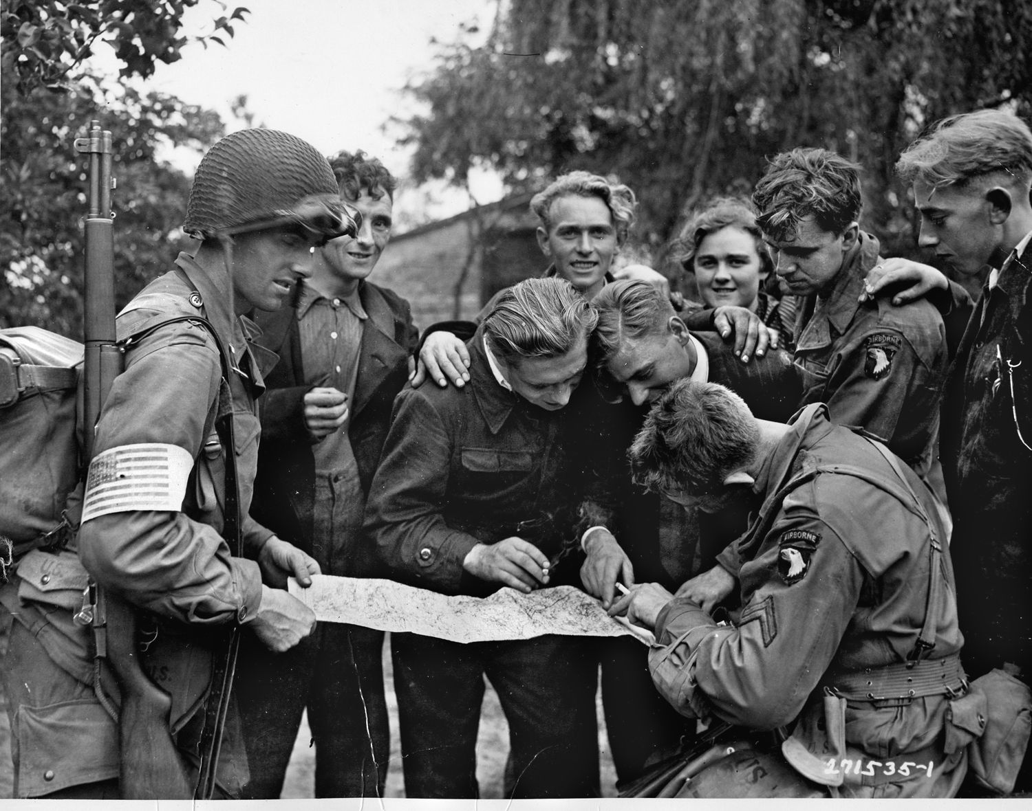 Dutch civilians show 101st Airborne soldiers the lay of the land in Holland. The locals hugged and kissed their liberators as they made their way into Eindoven.
