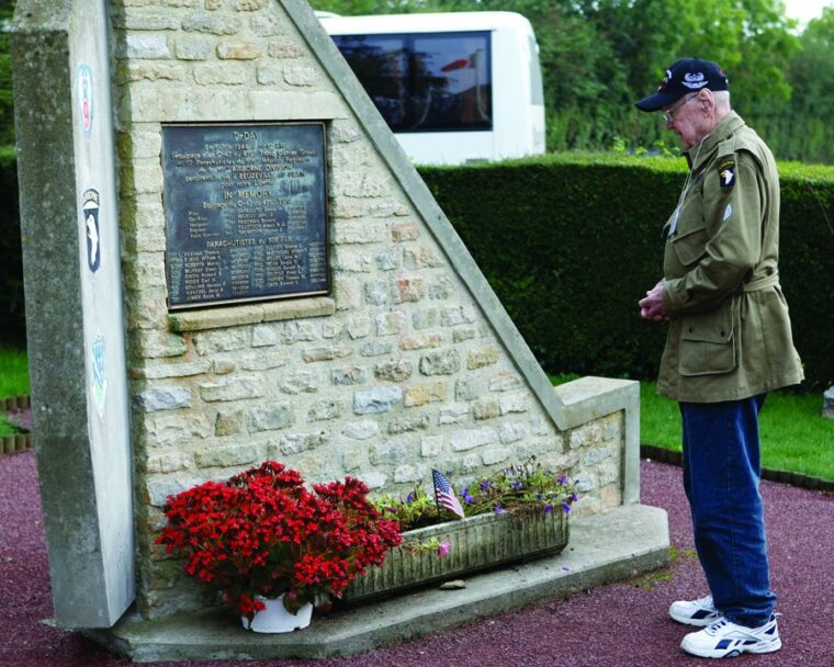 Ed Mauser pays tribute to his comrades who died in Lieutenant Thomas Meehan’s airplane at the crash site memorial in Normandy in 2010. The memory of the plane going down stayed with Mauser the rest of his life.