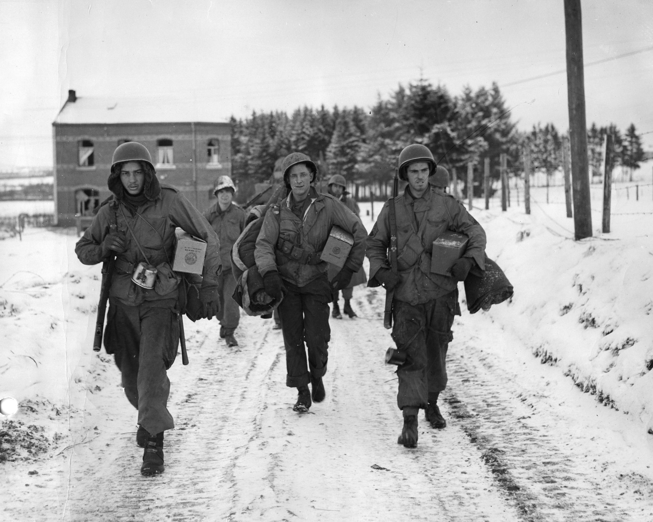 With newly acquired rations in hand, a group of paratroopers in surrounded Bastogne returns to the front line. Mauser ran into no man’s land to retrieve a supply container dropped by parachute.