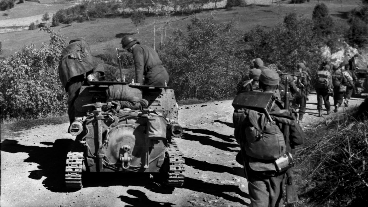 Accompanied by an Italian military vehicle, German mountain troops advance along a dirt road in Albania in 1943.