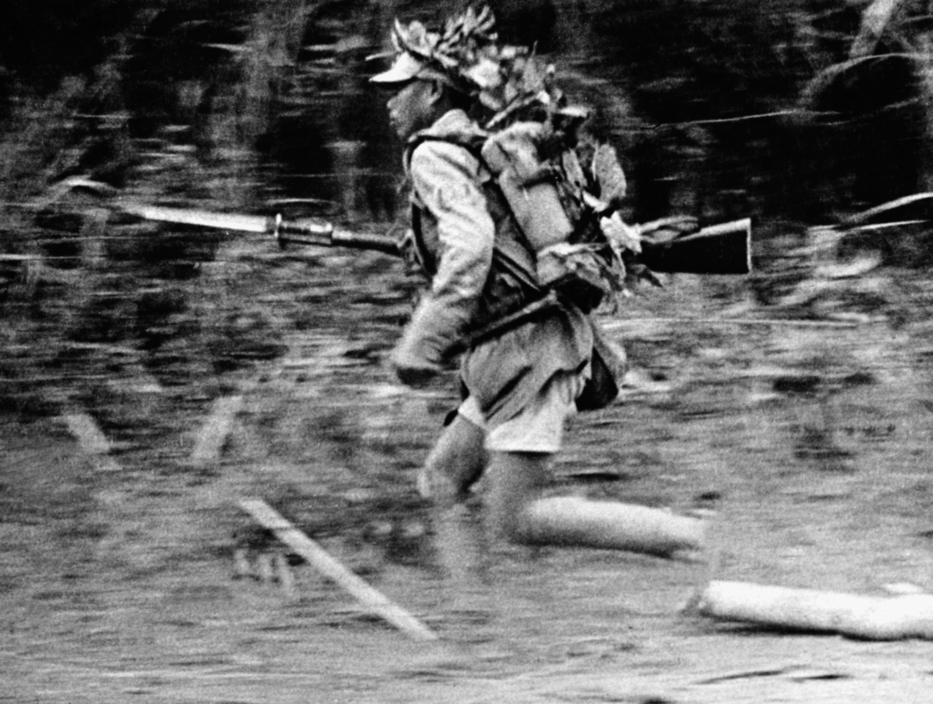 Hearing the sound of gunfire, a Japanese soldier moves swiftly through a section of jungle during an engagement in Burma,1944.