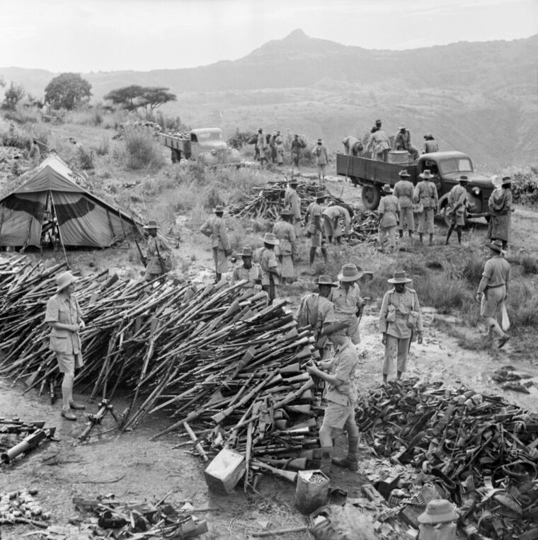Heaps of Italian weapons captured at Wolchefit Pass on September 28, 1941, are inspected by British soldiers of the King’s African Rifles. Many of these weapons were later used to equip colonial troops.