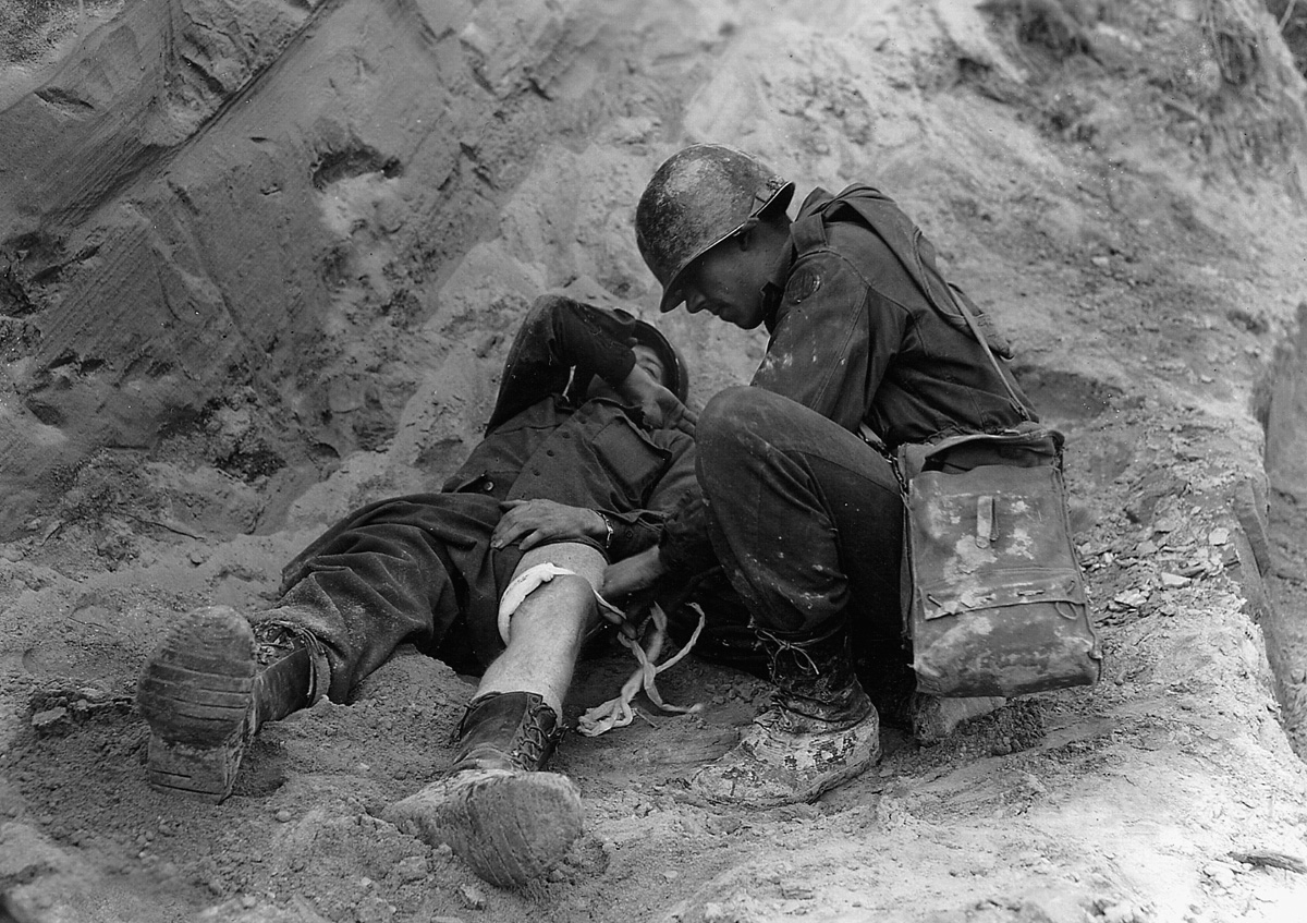 A wounded soldier of the 85th Infantry Division receives medical attention from a corpsman.