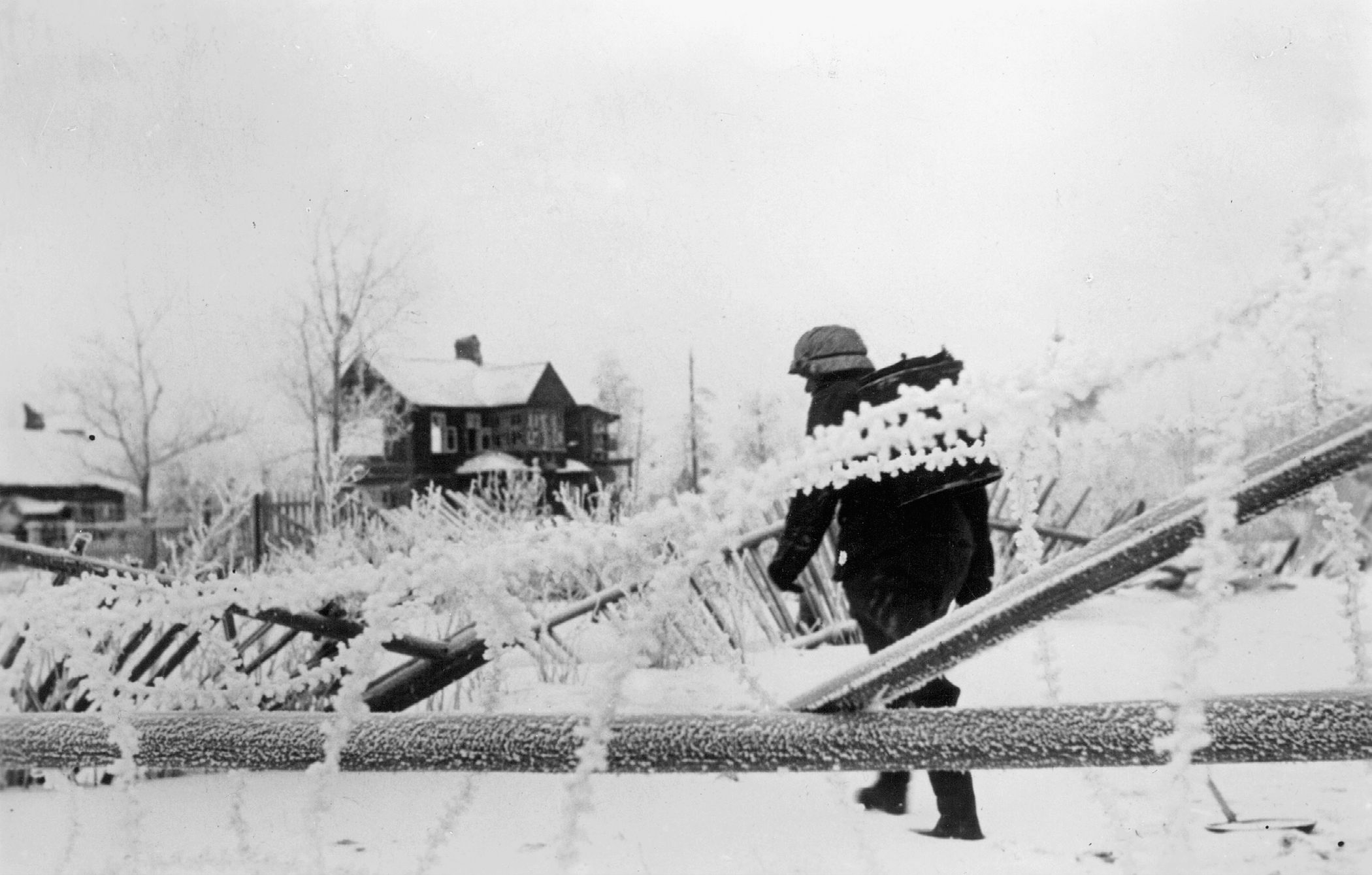A German soldier slogs through snow toward a field kitchen at his unit’s winter quarters near Leningrad. This man had drawn the hazardous duty of transporting food to troops on the front line by means of a sled.