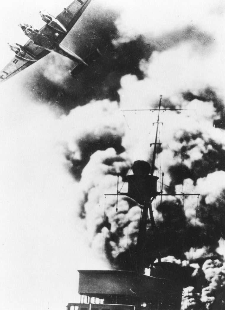 A German Me-110 fighter streaks over a smoking German destroyer during the intense fighting of April 5, 1940. 