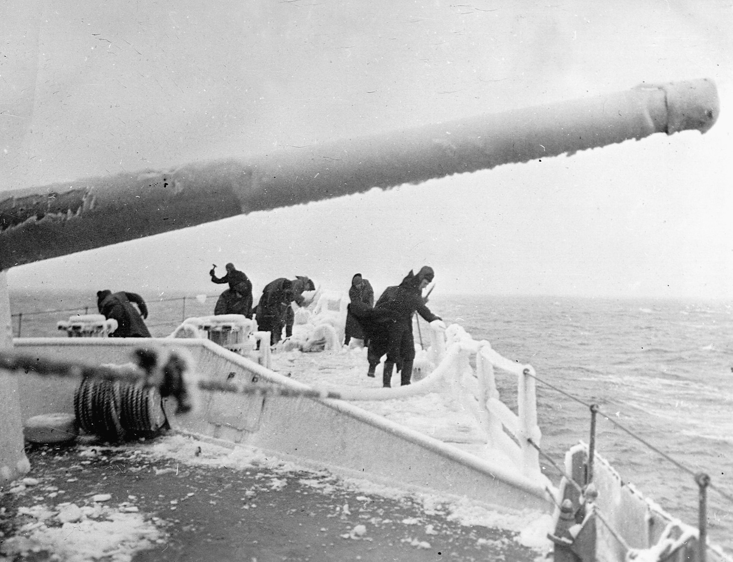 Crew members attempt to clear the ice from the frozen deck of their destroyer.