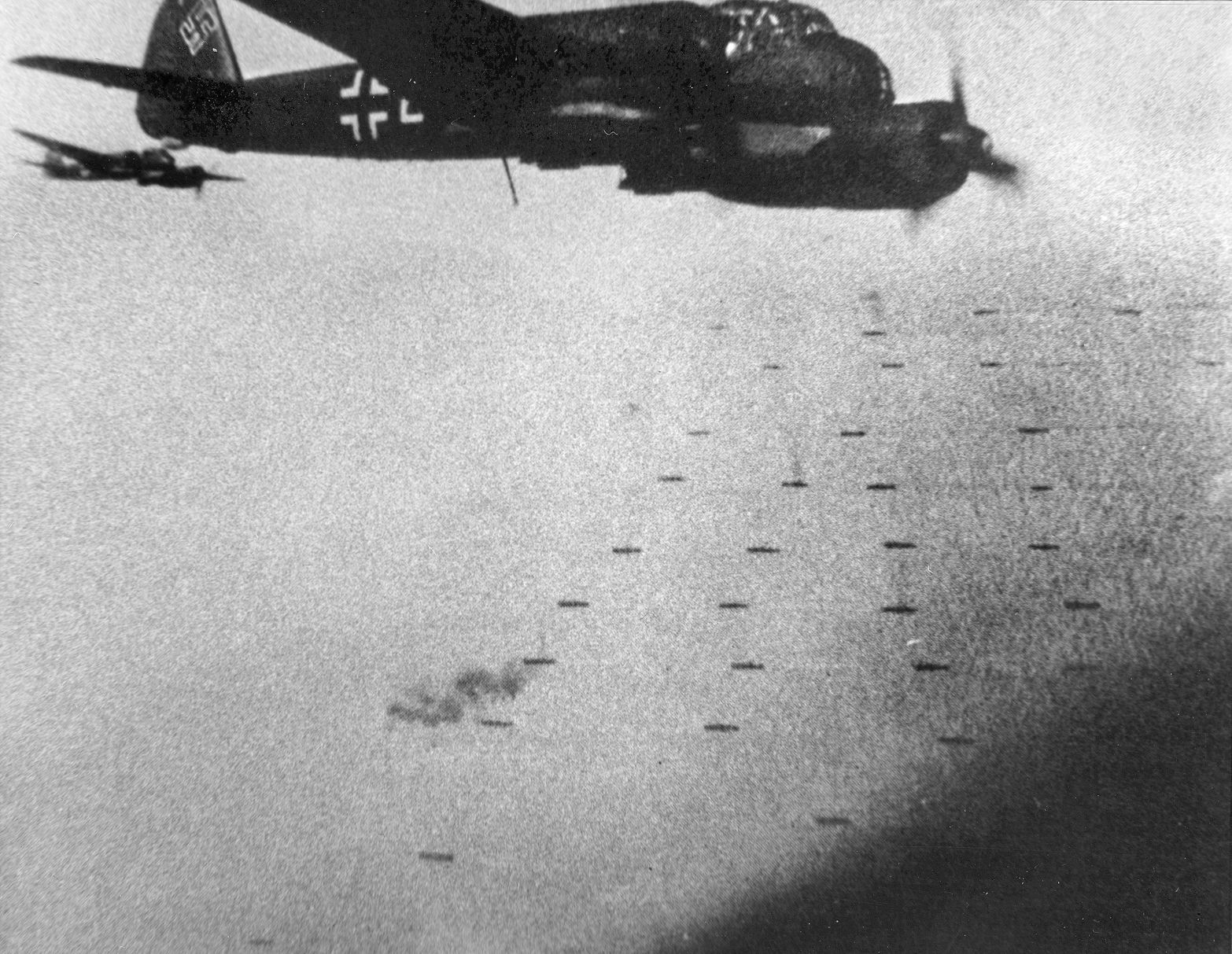 The tight formation of Convoy PQ-17 before the order to scatter was received is visible below a high-flying German Junkers Ju-88 bomber.