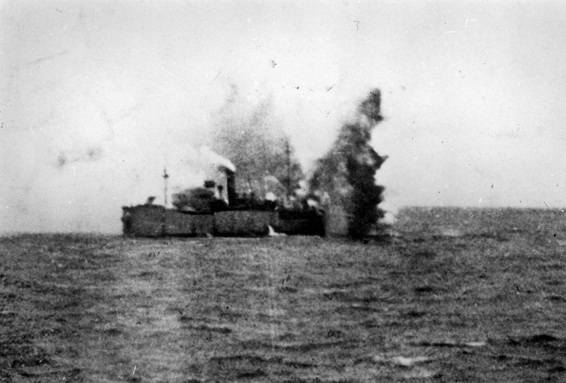 The British freighter Navarrino takes a hit from a torpedo launched by a German Heinkel He-111 bomber rigged to carry the deadly aerial ordnance.