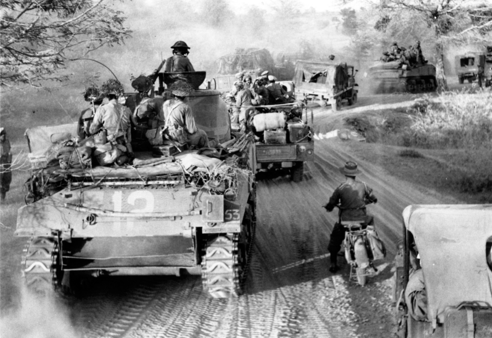 Advancing on the road between Myaungyu on the Irrawaddy River and Meiktila, Sherman tanks and vehicles of the British 62nd Motorized Brigade keep a strenuous pace, March 1945.