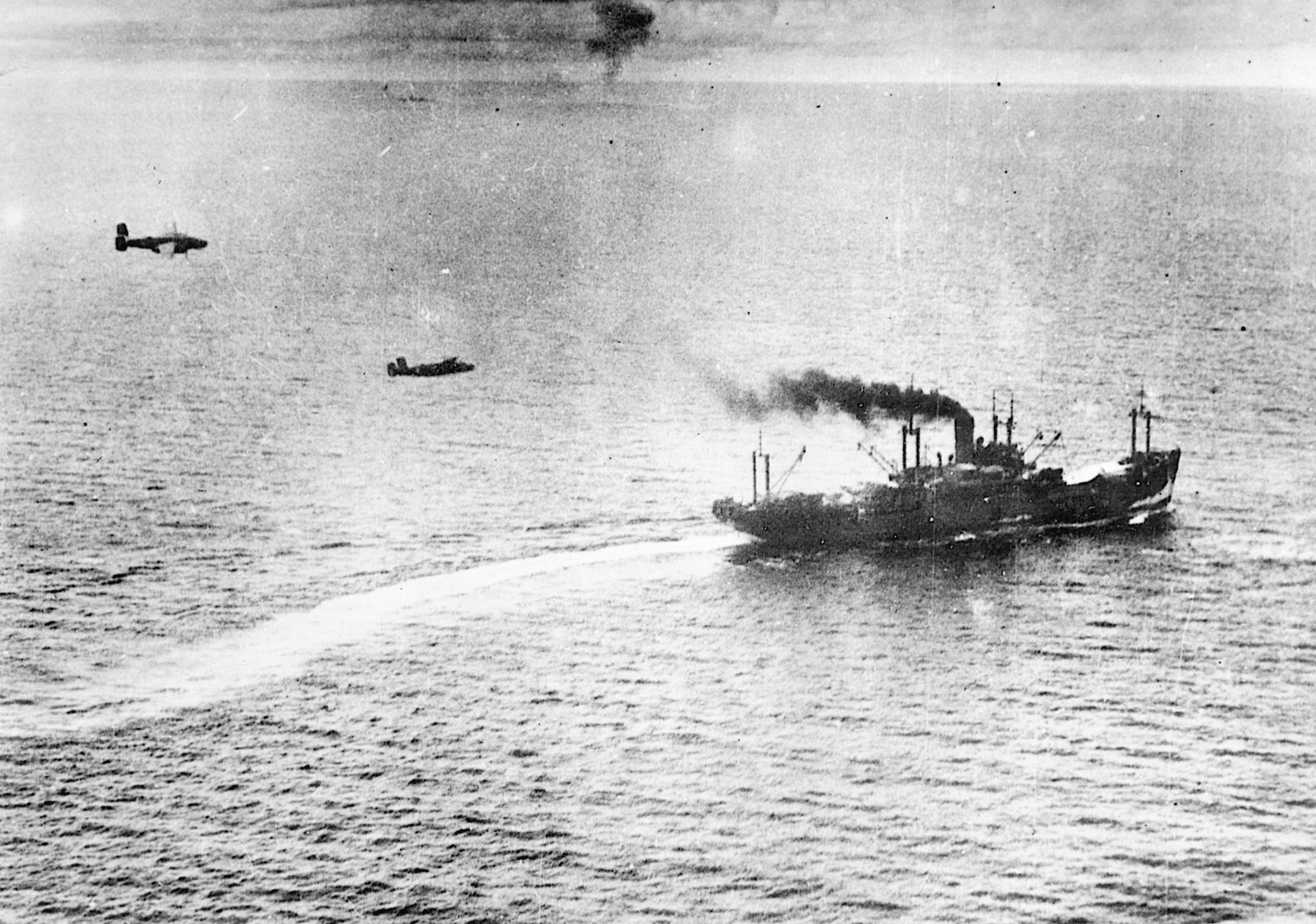 Sweeping in at mast height, a pair of U.S. medium bombers prepares to drop its payload on a Japanese merchant ship during the Battle of the Bismarck Sea.