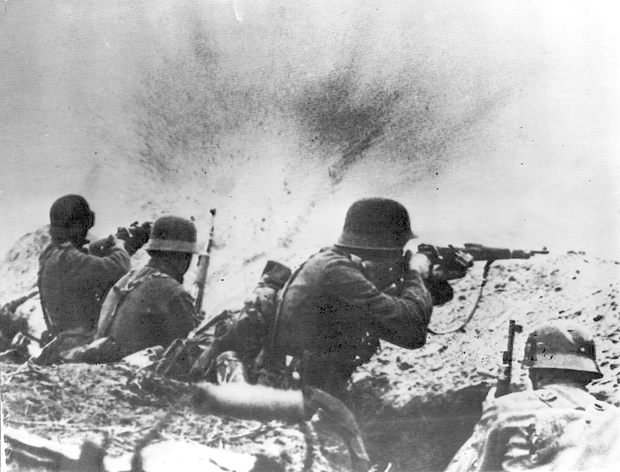 In the heat of combat, German soldiers crouch and fire their weapons feverishly from a trench line as Soviet marines advance against them.