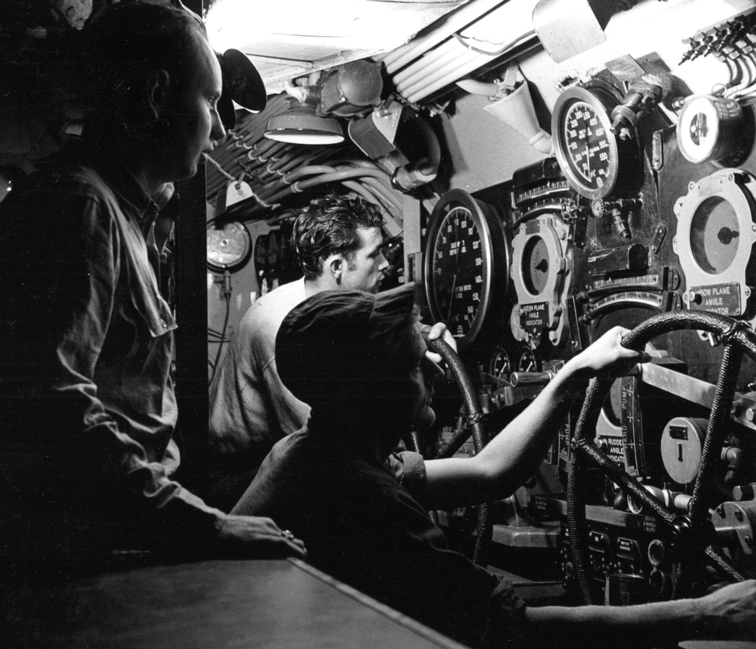 The diving officer and two enlisted men prepare to send the USS Batfish into a dive on May 1, 1945.