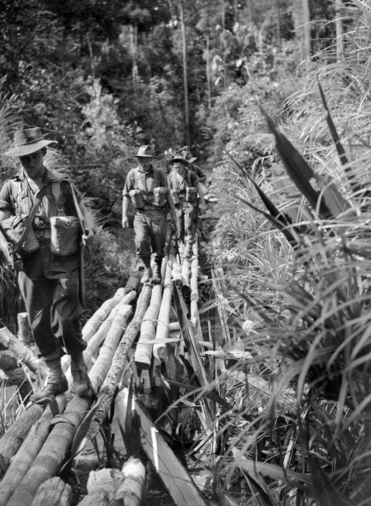 During a patrol on Tarakan Island, Borneo, on May 27, 1945, members of 2/4 Commando traverse a flimsy bridge constructed of logs.