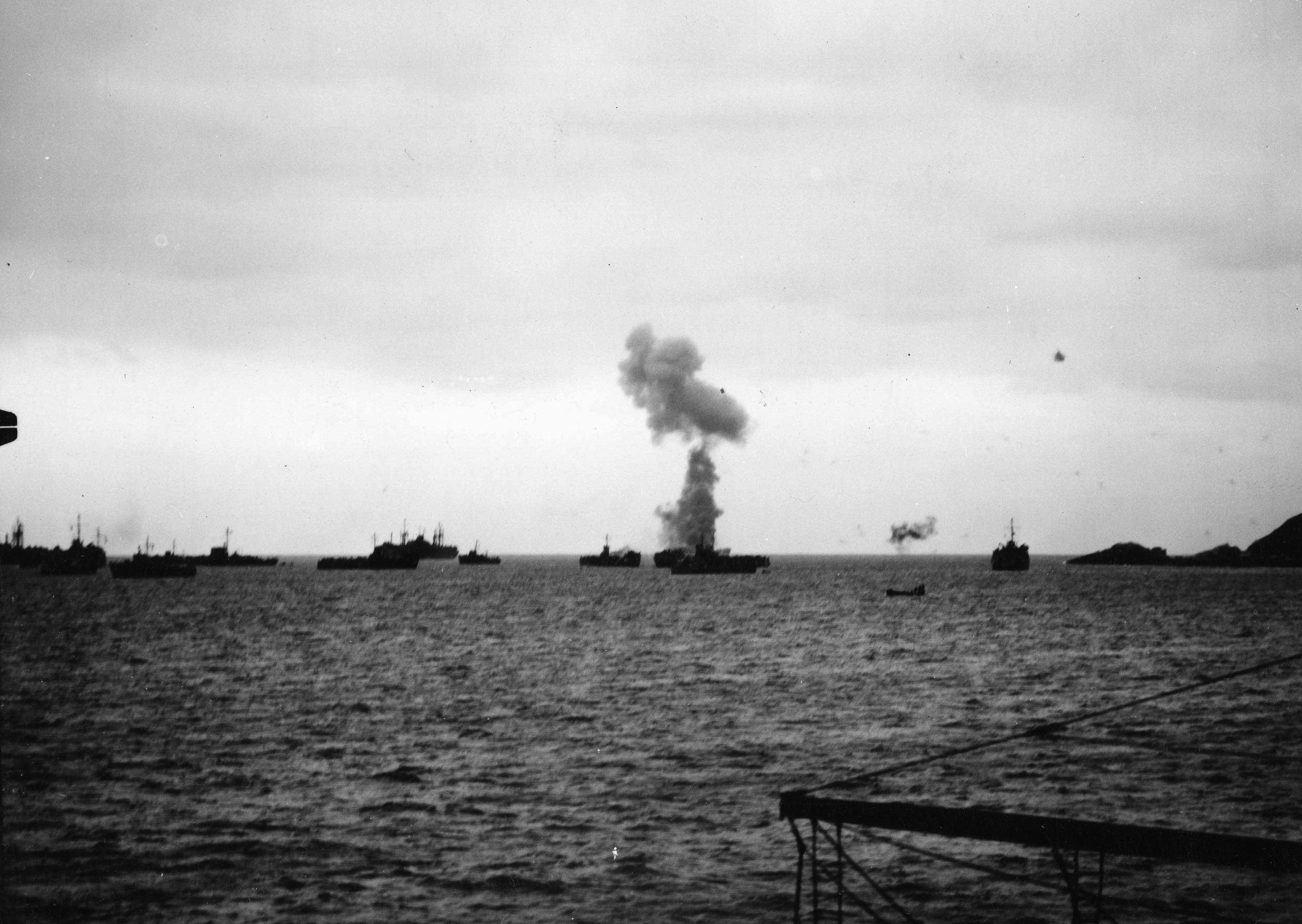 Smoke billows from a U.S. vessel that has just sustained a bomb hit during a Japanese air raid off Okinawa. This photograph was taken from the deck of the transport USS Chandeleur. (National Archives)