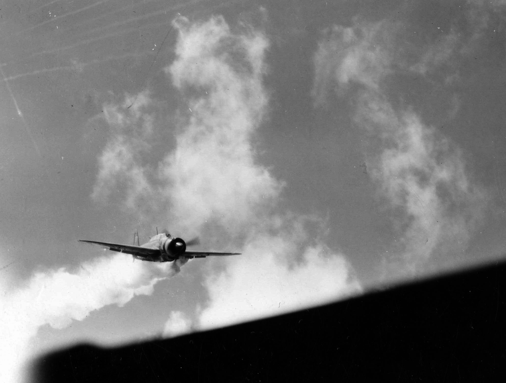 A Japanese dive-bomber, its pilot bent on a suicide crash into the aircraft carrier USS Essex, streams thick smoke during its final plunge. (National Archives)