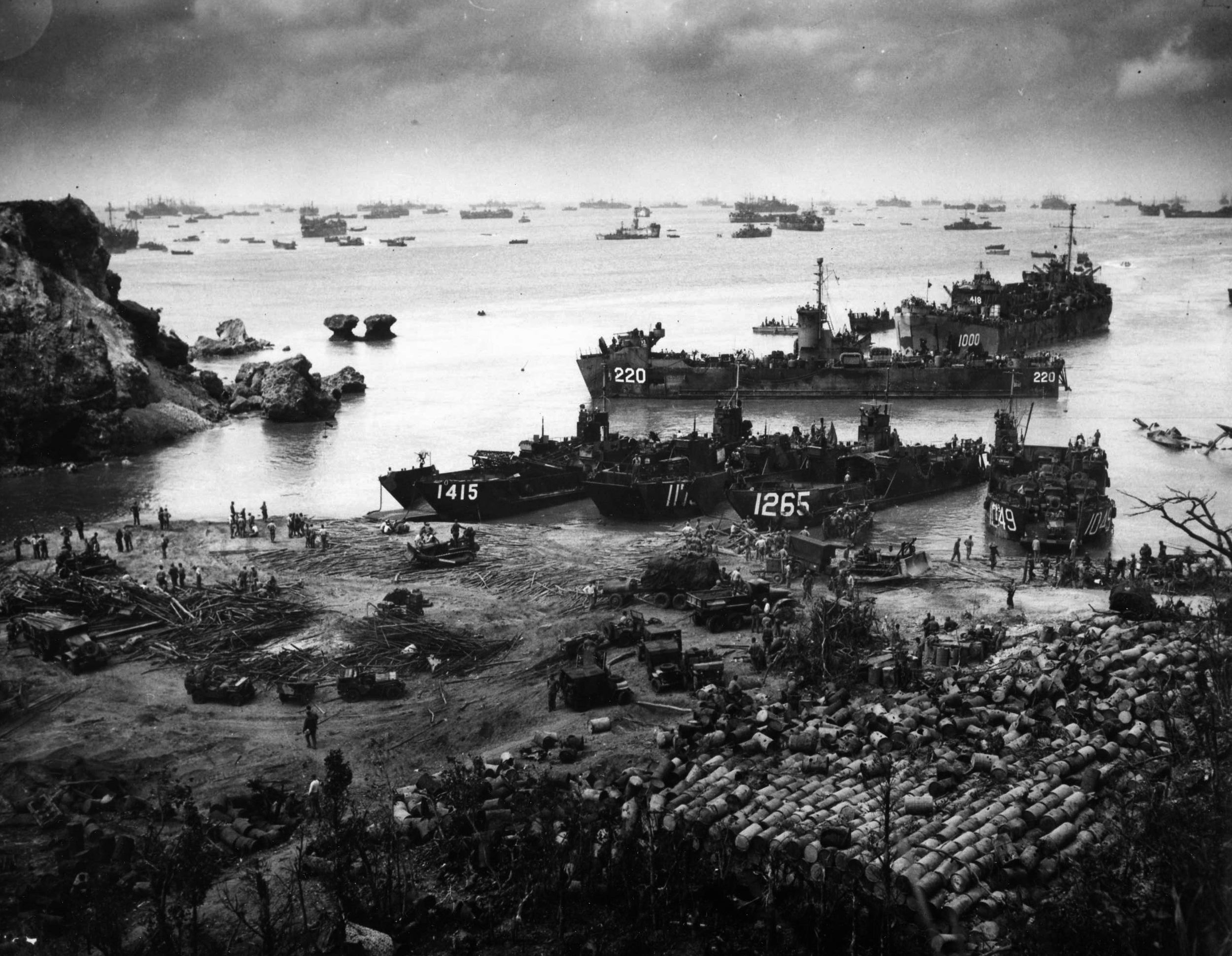 On April 13, 1945, almost two weeks after the initial U.S. landings on Okinawa, U.S. troops may be seen ashore while supply and transport vessels crowd the beach and stretch for miles out to sea. (U.S. Coast Guard)