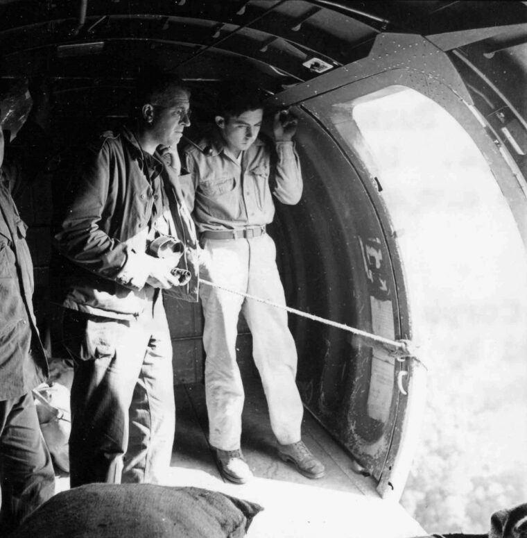 Standing in the open doorway of a C-47 transport on April 16, 1944, Brig. Gen. Frank Merrill, commander of the famed Marauders, watches the countryside of northern Burma pass below. At right is Sergeant Donald Ross, the dropmaster for the flight, which was en route to resupply Merrill’s command.