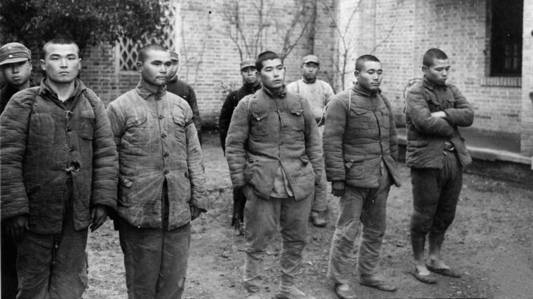 En route to the Chinese 74th Army headquarters at Wukong, five Japanese prisoners are marched out of the guerrilla headquarters at Tien Toh. All five appear to be well fed and clothed. (National Archives)
