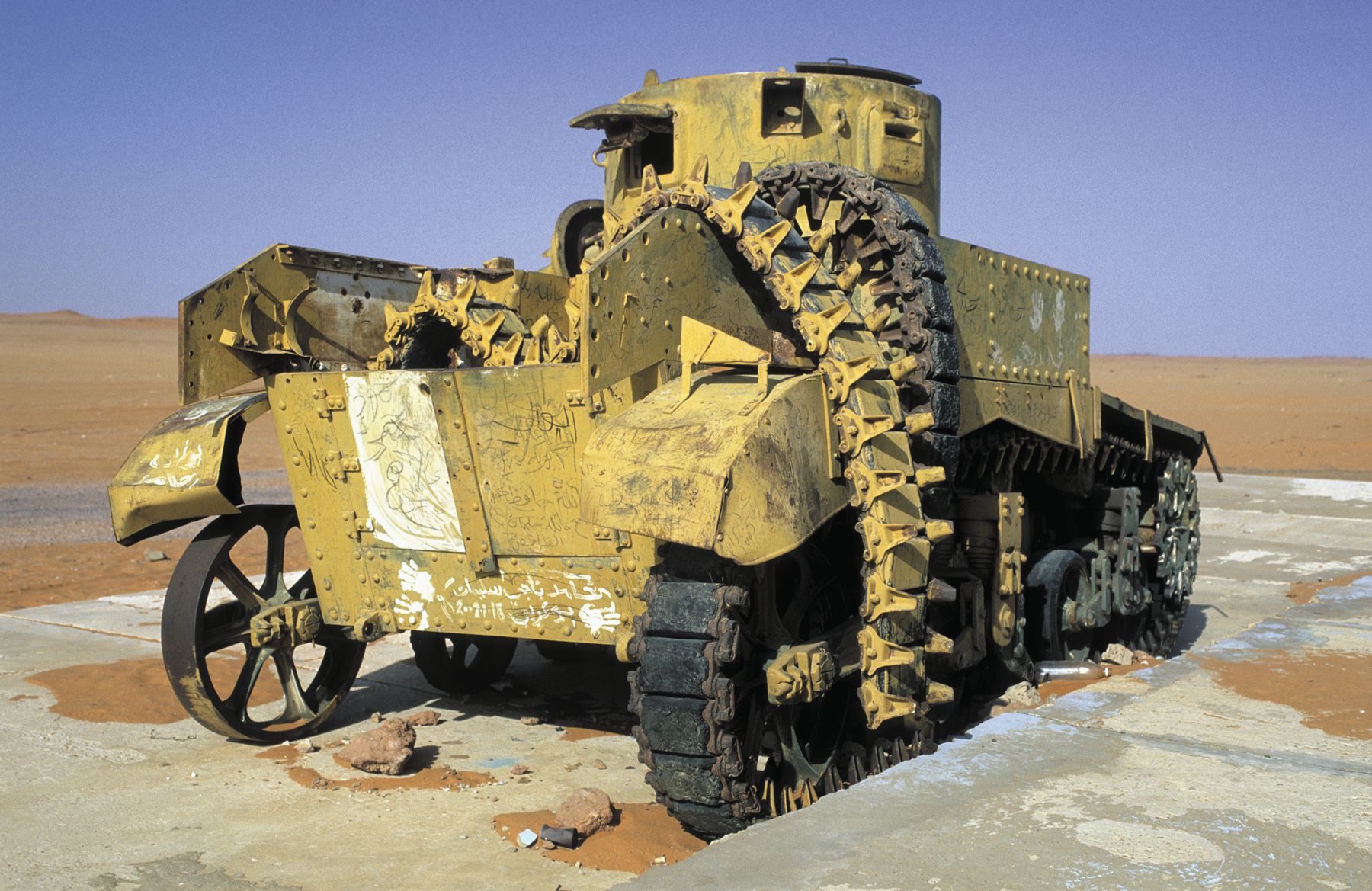 A disabled Italian tank sits motionless in the desert of Libya. A large piece of its track appears draped across the chassis. (ullstein-bild)