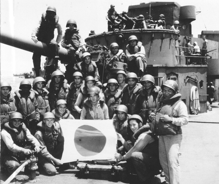 Antiaircraft gun crews aboard the Taney pose with a captured Japanese flag during the Battle of Okinawa.