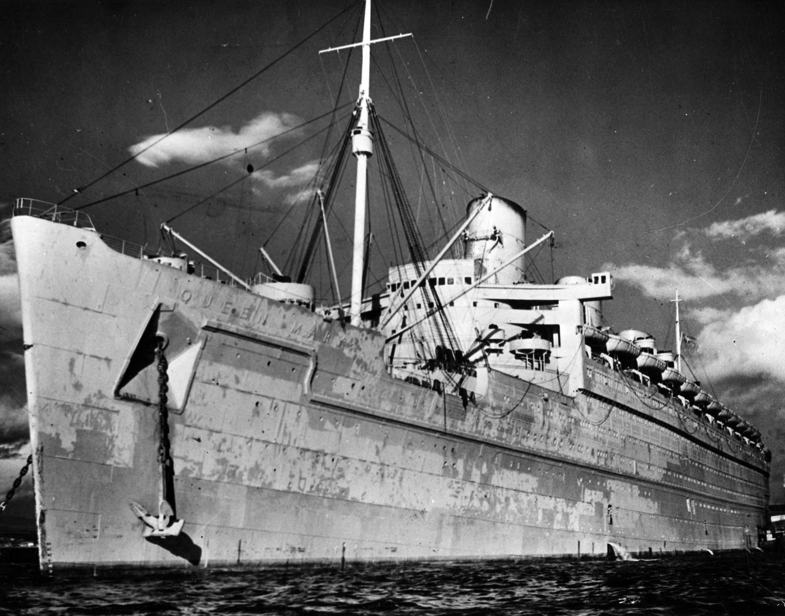 Painted in dull wartime colors, the Queen Mary looks every bit the troop ship she was reconditioned to be in this December 1944 photo. During the war, the luxury liner transported thousands of troops from North America to Europe.