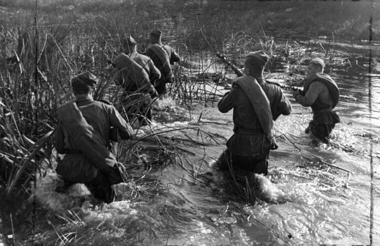 In September 1944, Red Army soldiers wade through a marshy area during a patrol. Such terrain played an important role on the Taman Peninsula as both armies had to contend with mobility issues.