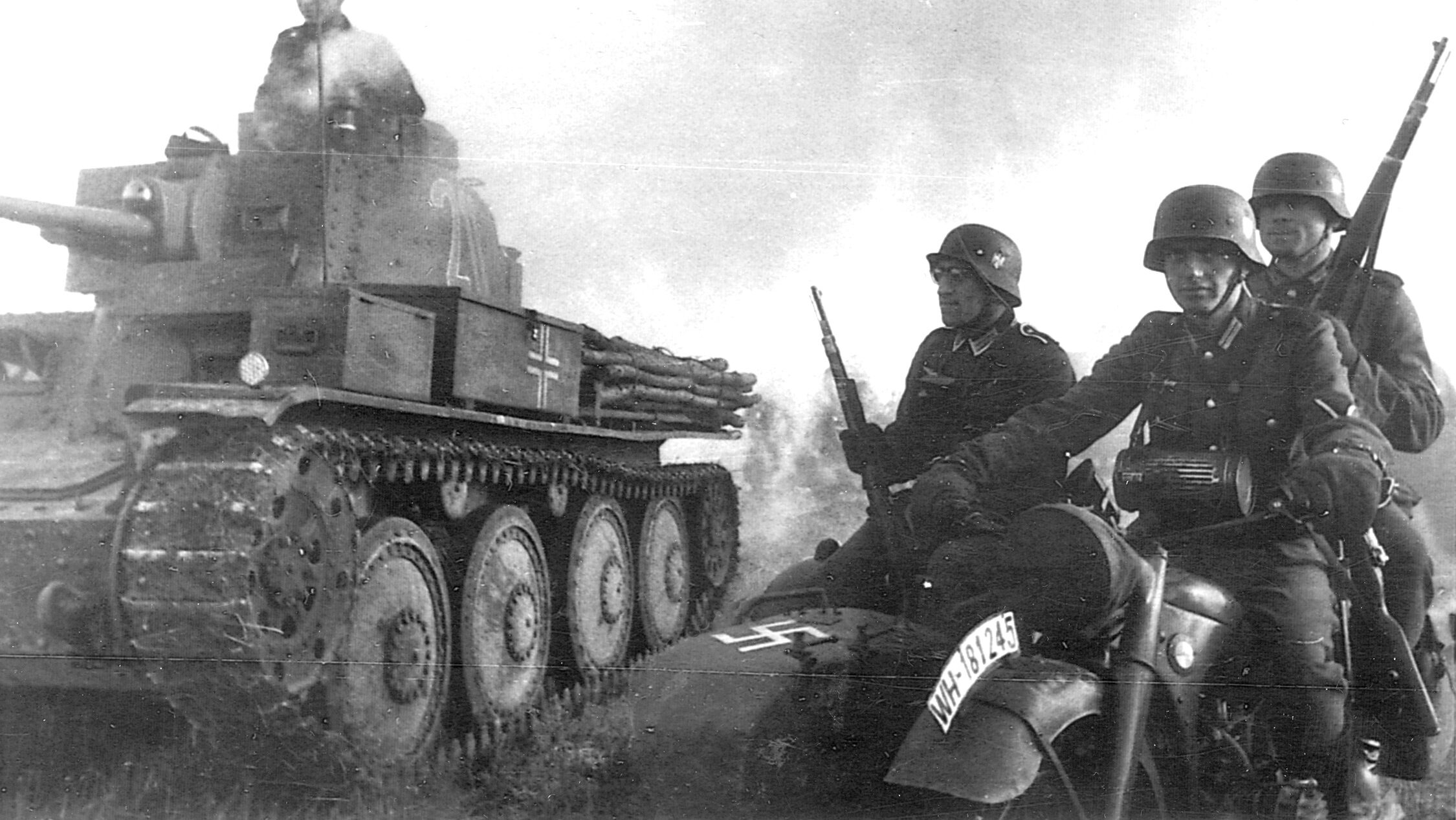 Early in the war, German troops advance in the company of a Czech-made tank and under cover of a smoke bomb they have ignited. The German occupation of Czechoslovakia provided the Wehrmacht with a windfall of military hardware.