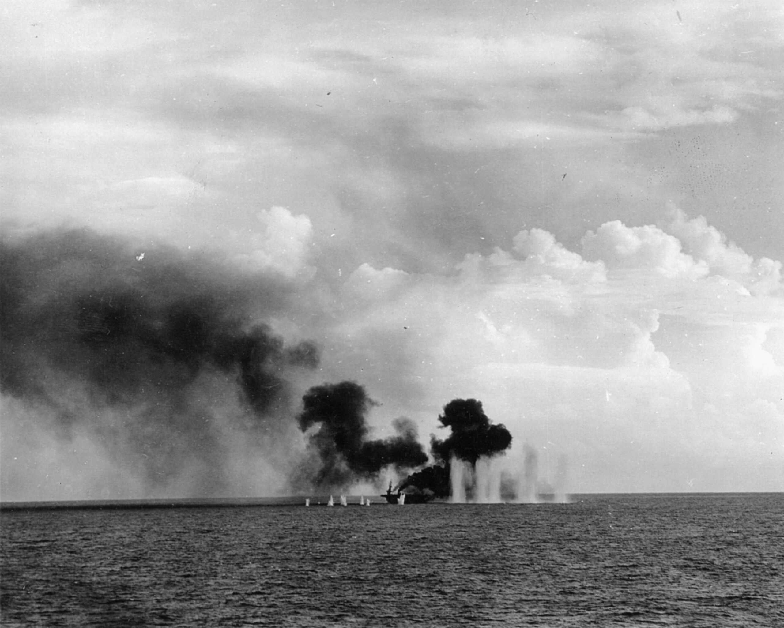 The escort carrier USS Gambier Bay is bombarded by heavy shells from Japanese cruisers. Already spewing smoke, the vessel was lost during the the fight off Samar.