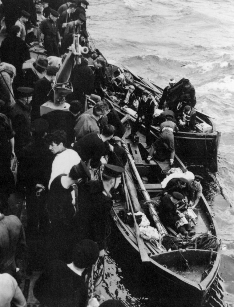 Their merchant ship sunk by enemy fire, survivors of the harrowing ordeal are plucked from their lifeboat by crewmen of a Canadian rescue vessel.