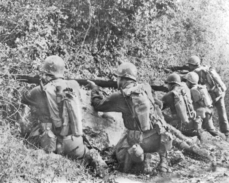 Slugging their way through the mountains of Central Italy, U.S. Rangers lay down covering fire from a well-concealed position as other members of their squad execute the technique of fire and maneuver. 