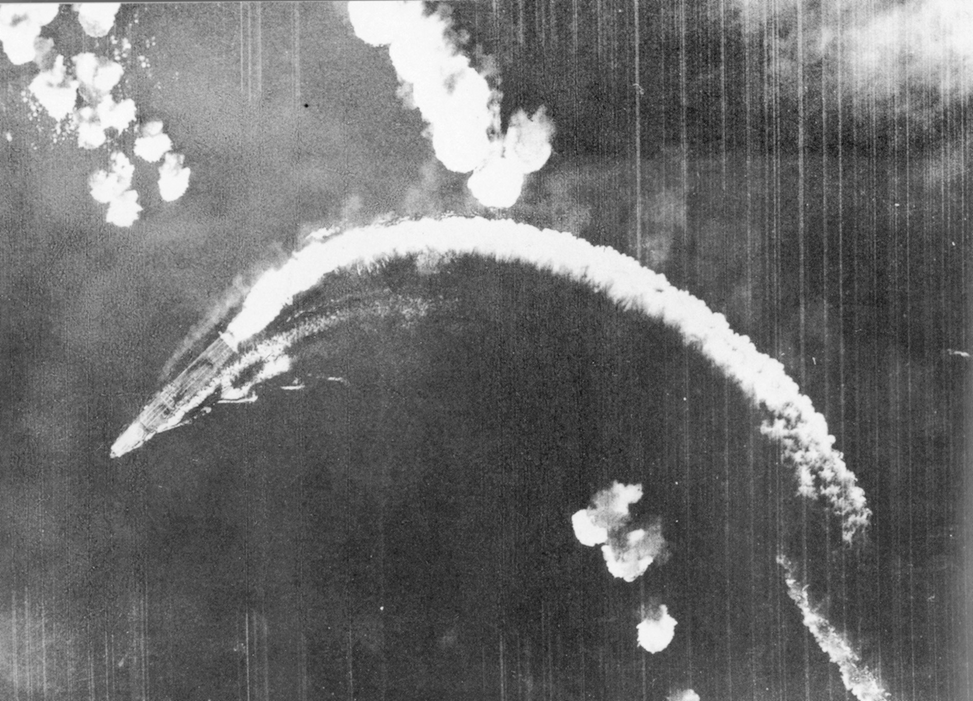 The Japanese carrier Akagi takes evasive action as bombs from U.S. planes fall into the sea. 