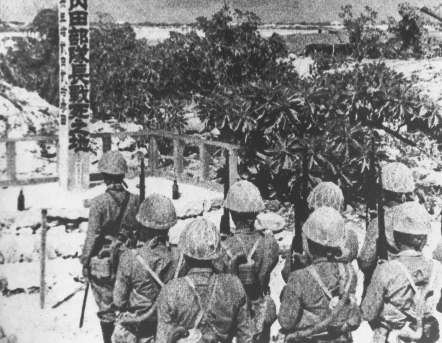 Japanese troops pay respect to a fellow soldier killed in action on Wake.