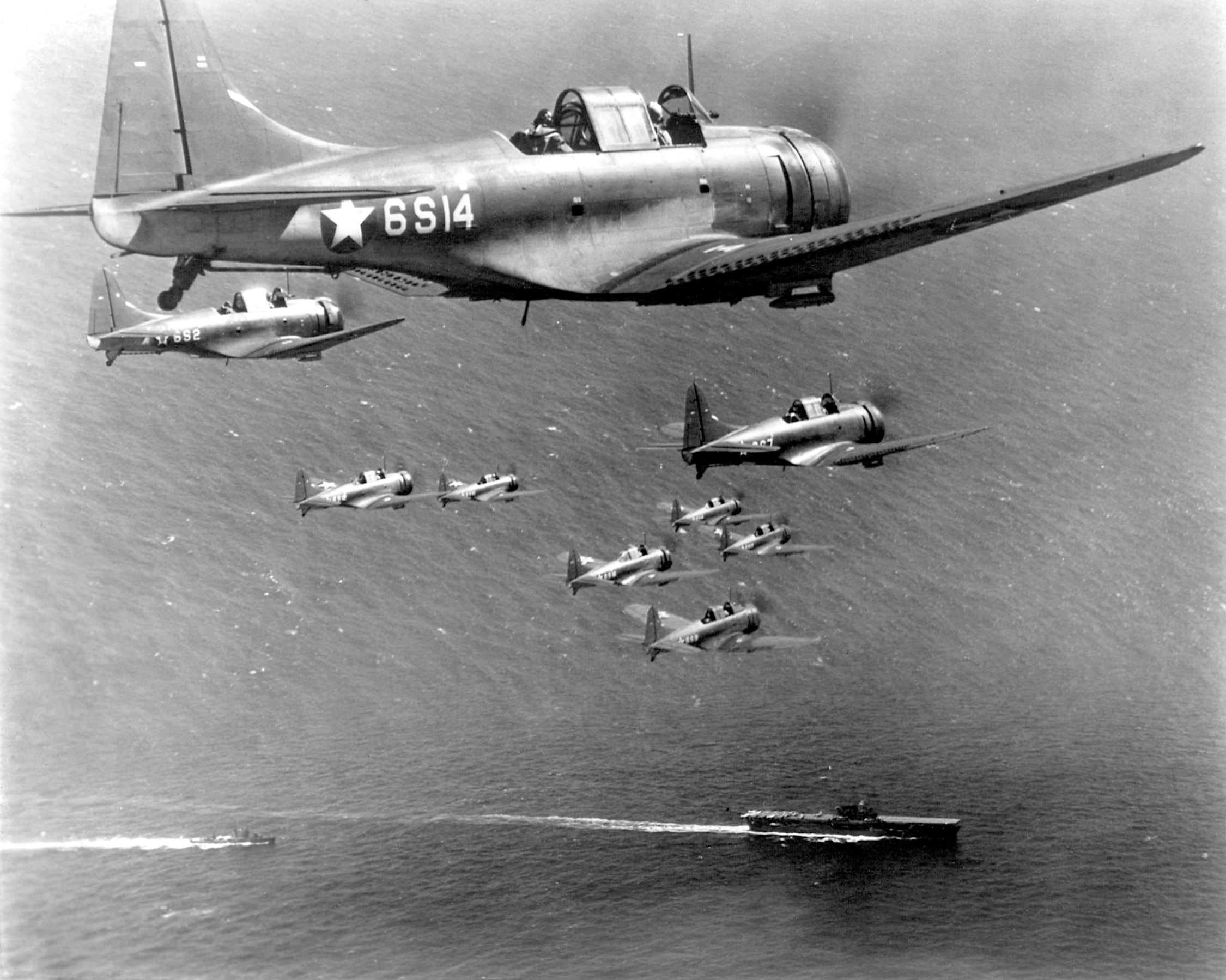 Flying in formation, a squad of Dauntless dive-bombers from Scout Squadron Six return to the USS Enterprise.