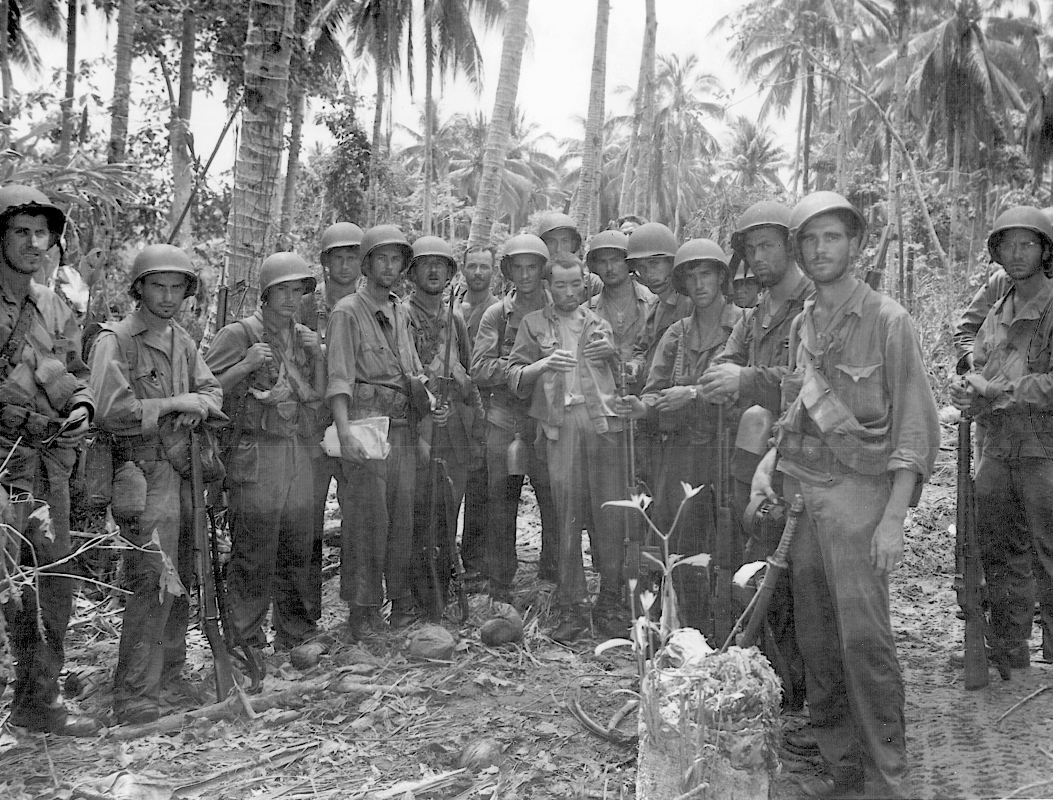 A U.S. Marine patrol pauses for a photograph after completing a reconnaissance mission on Guadalcanal. Their Japanese prisoner is a rare find indeed since enemy troops refused to be taken alive.