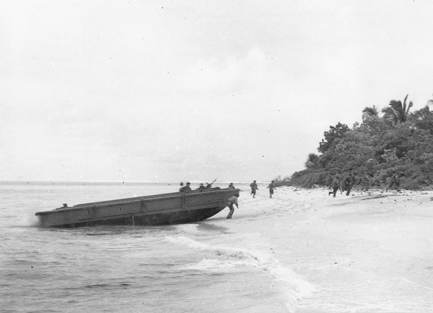 Moving quickly from their landing craft and into the relative safety of the jungle, American troops head toward their objective on the strategically vital island of Guadalcanal.