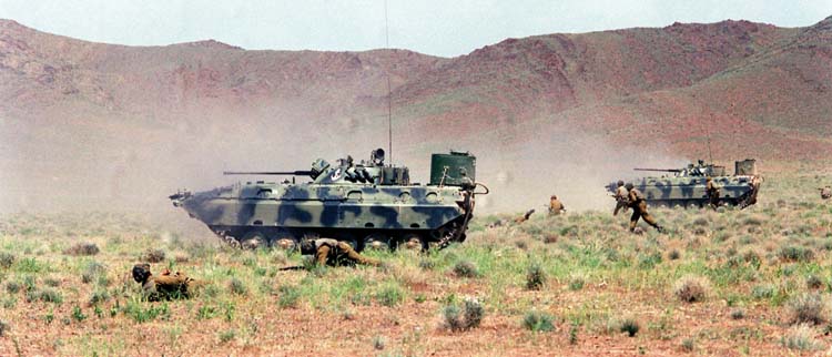 Crouching Soviet troops accompany BMP-1 tanks across the forbidding Afghan countryside in 1988. More than 15,000 Russian soldiers would be lost in the war. 