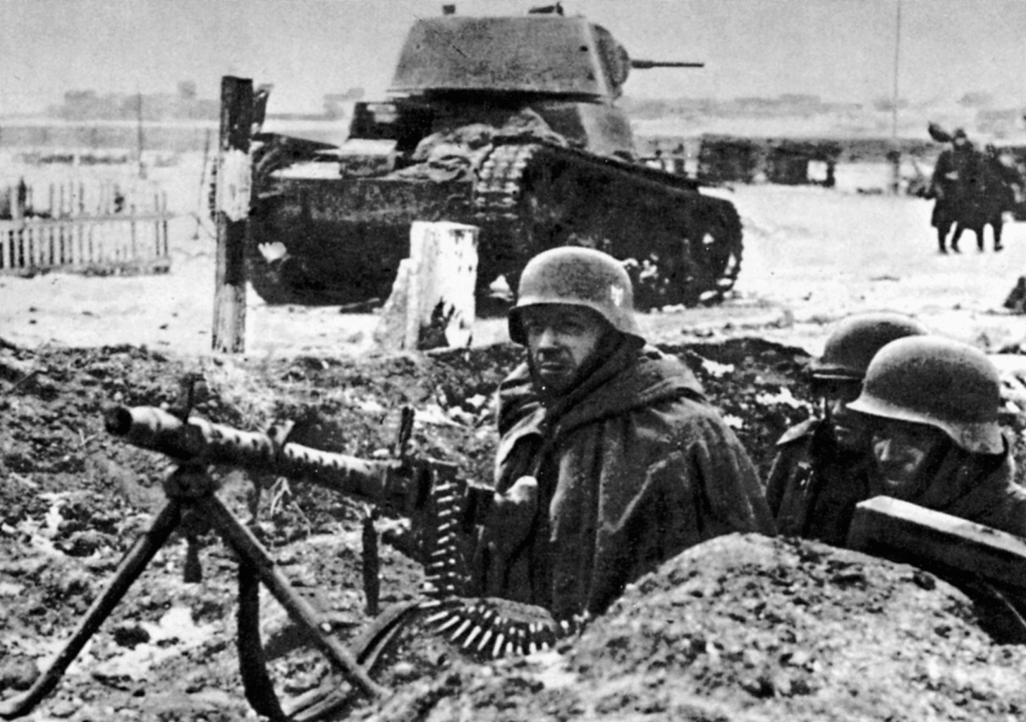With the wreckage of a Soviet T-34 behind them, a German MG-34 machine gun crew scans the horizon for signs of a Red Army attack.